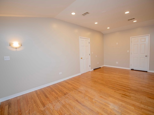 unfurnished room featuring light wood-type flooring and vaulted ceiling