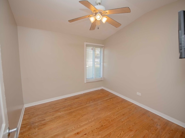 empty room with ceiling fan, light hardwood / wood-style flooring, and vaulted ceiling