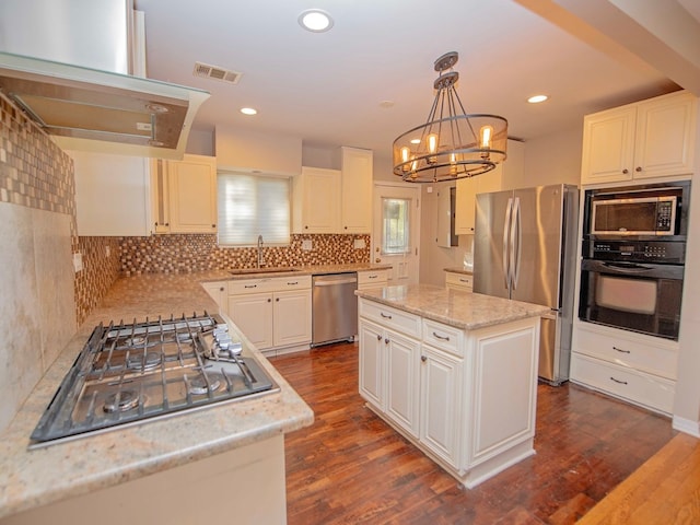 kitchen with white cabinetry, sink, appliances with stainless steel finishes, hanging light fixtures, and a center island