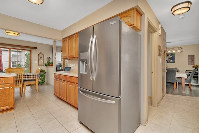 kitchen featuring light tile patterned flooring, pendant lighting, and stainless steel refrigerator with ice dispenser