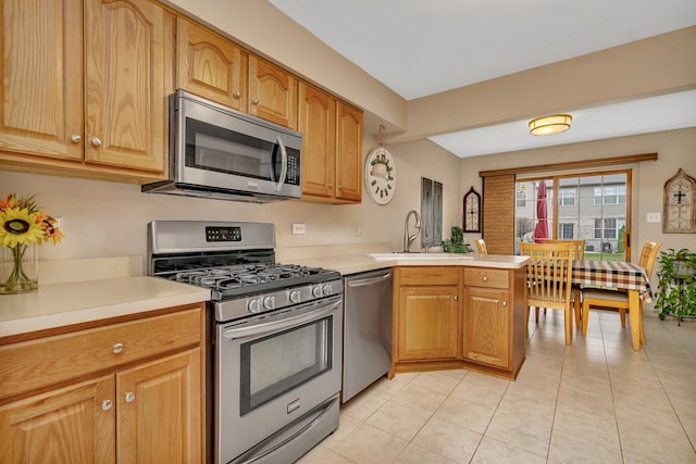 kitchen featuring light tile patterned flooring, sink, kitchen peninsula, and stainless steel appliances