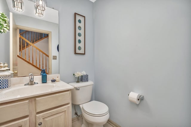 bathroom with vanity, toilet, and a chandelier