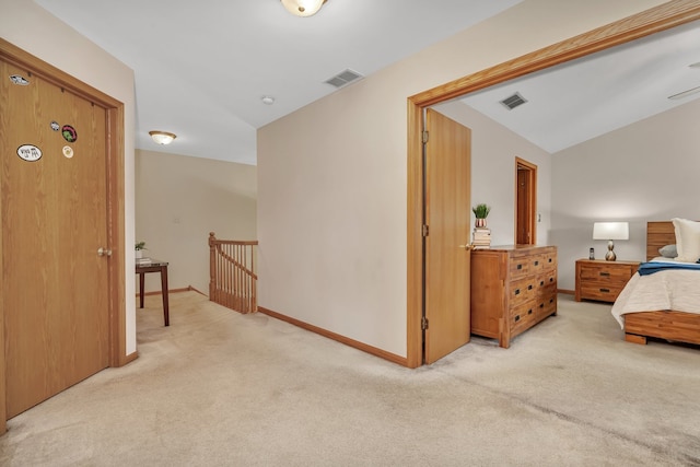 hallway featuring light colored carpet and vaulted ceiling