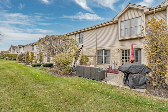 rear view of property featuring a patio area, an outdoor living space, and a yard