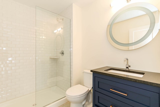 bathroom featuring toilet, vanity, and tiled shower