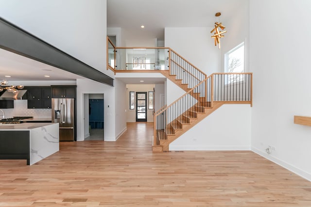 entryway featuring light wood-type flooring, an inviting chandelier, and a healthy amount of sunlight