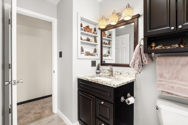 bathroom featuring toilet, vanity, and hardwood / wood-style flooring