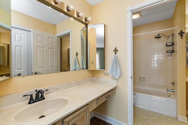 full bathroom featuring toilet, tiled shower / bath combo, vanity, and tile patterned floors