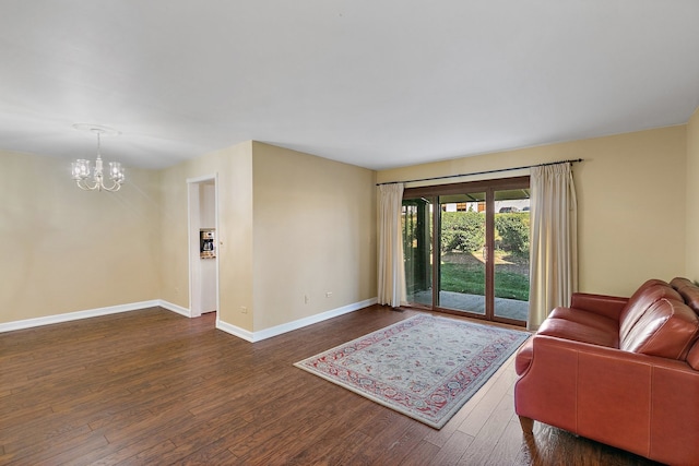 living room featuring an inviting chandelier and dark hardwood / wood-style floors