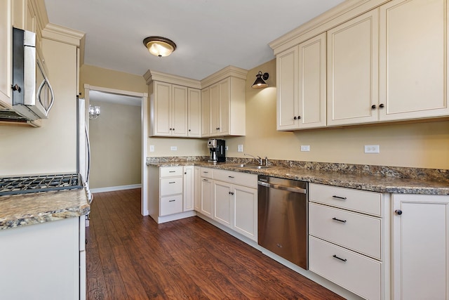 kitchen with stainless steel appliances, dark wood-type flooring, cream cabinets, and sink