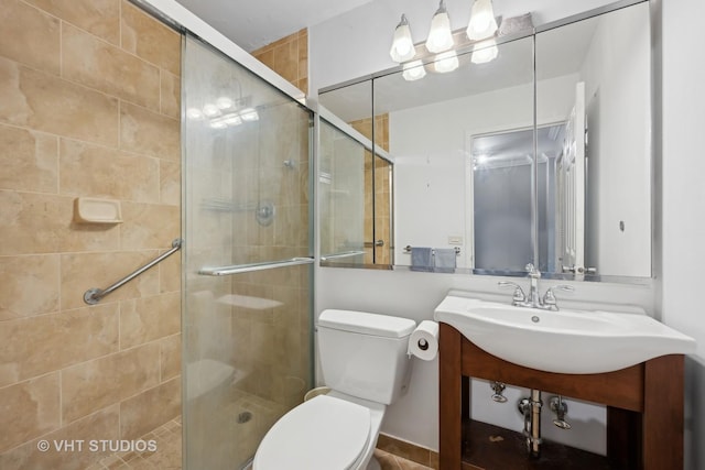 bathroom with vanity, toilet, and a shower with door