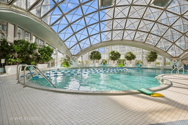 view of swimming pool with glass enclosure and a patio area