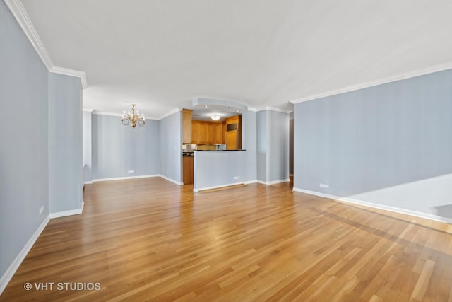 unfurnished living room featuring light wood-type flooring, an inviting chandelier, and ornamental molding