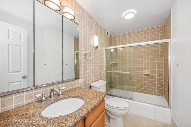 full bathroom with tile patterned flooring, combined bath / shower with glass door, backsplash, toilet, and tile walls