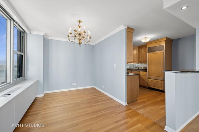 unfurnished dining area featuring a notable chandelier, plenty of natural light, and light hardwood / wood-style floors