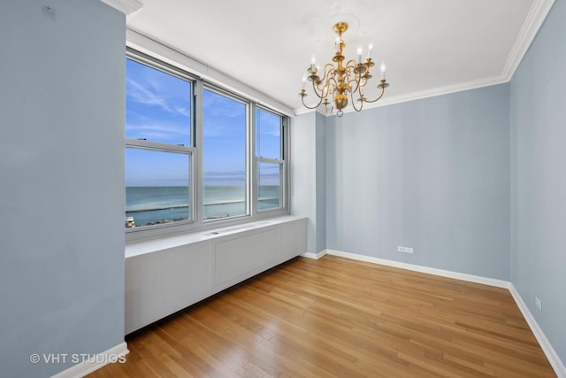 unfurnished room with crown molding, a water view, a notable chandelier, and light wood-type flooring