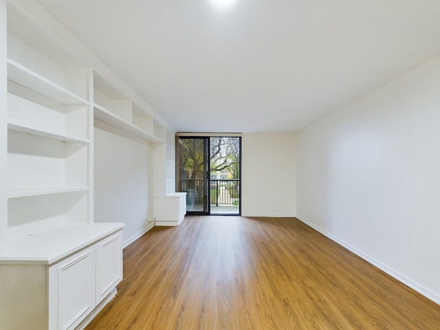 empty room featuring light hardwood / wood-style flooring and floor to ceiling windows