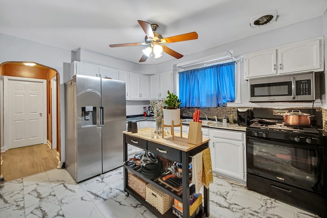 kitchen featuring white cabinets, sink, decorative backsplash, ceiling fan, and stainless steel appliances