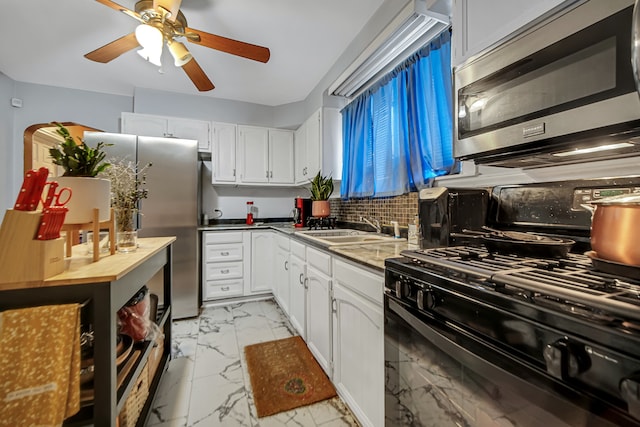 kitchen with white cabinets, sink, decorative backsplash, ceiling fan, and stainless steel appliances