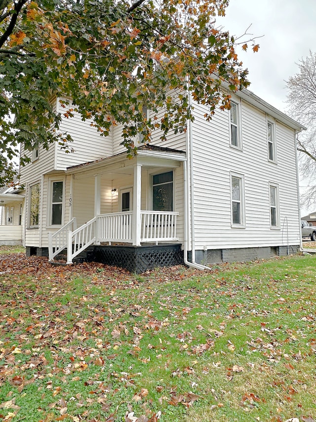 exterior space with covered porch and a lawn