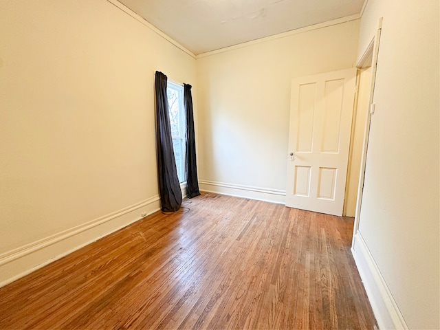 spare room with hardwood / wood-style floors and crown molding