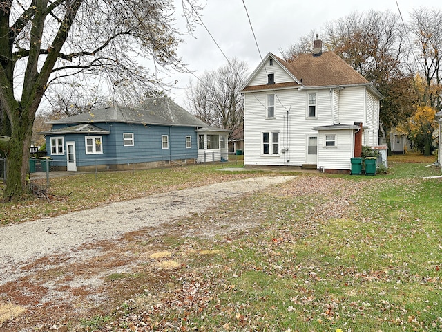 rear view of house featuring a lawn