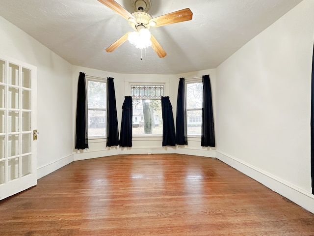 empty room featuring ceiling fan, a textured ceiling, and light wood-type flooring