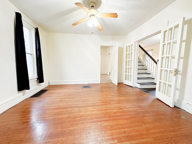 unfurnished room with ceiling fan, french doors, and light hardwood / wood-style flooring