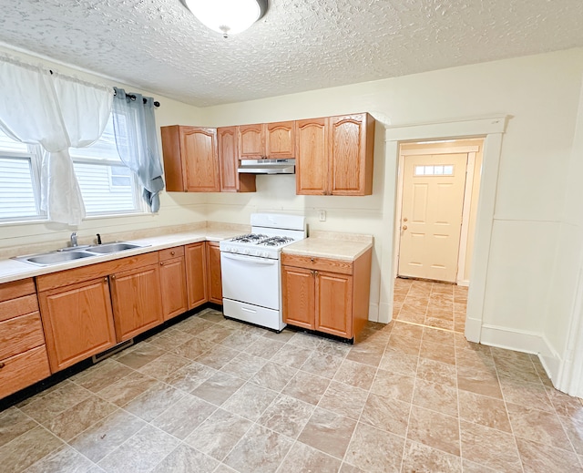 kitchen with a textured ceiling, gas range gas stove, and sink