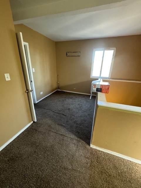 spare room with dark carpet