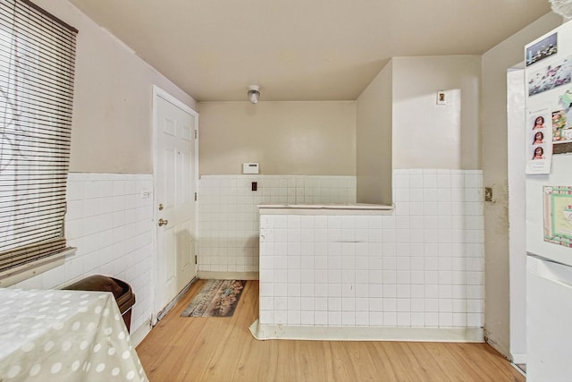 bathroom featuring hardwood / wood-style floors and tile walls