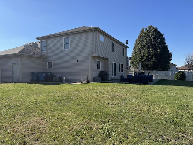 back of house with an outdoor living space, a yard, and central AC