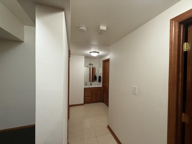 hallway with light tile patterned floors and sink