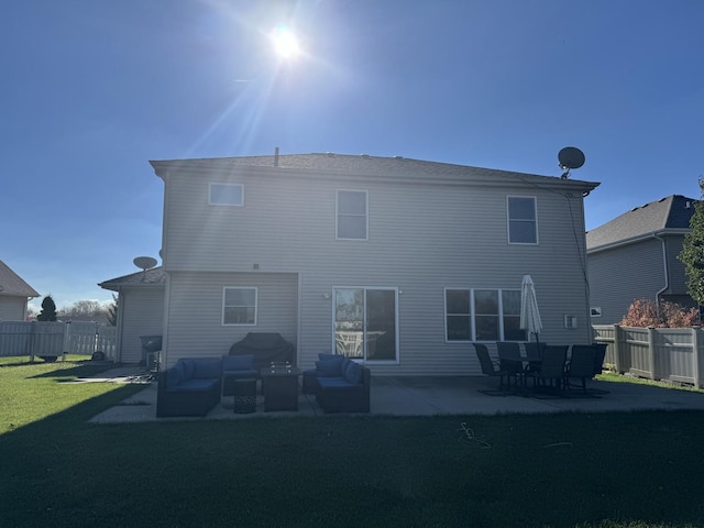 rear view of house with an outdoor living space, a patio area, and a lawn