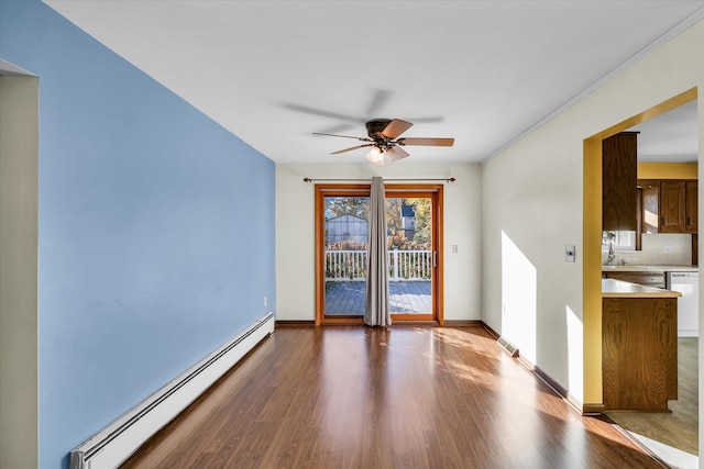 spare room with baseboard heating, hardwood / wood-style flooring, and ceiling fan