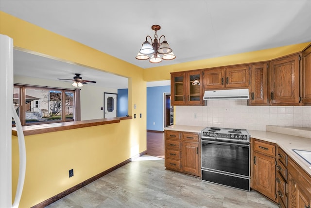 kitchen with decorative backsplash, decorative light fixtures, range with electric cooktop, and ceiling fan with notable chandelier