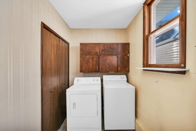 laundry area with cabinets, separate washer and dryer, and wooden walls