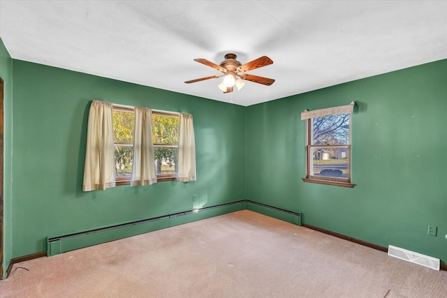 unfurnished room with a baseboard heating unit, ceiling fan, and carpet floors