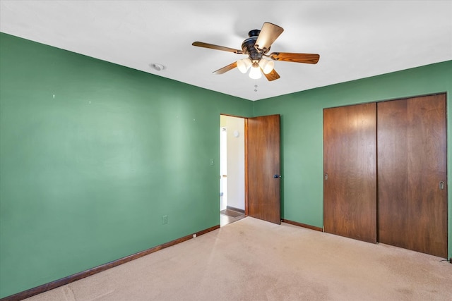 unfurnished bedroom featuring ceiling fan, light colored carpet, and a closet