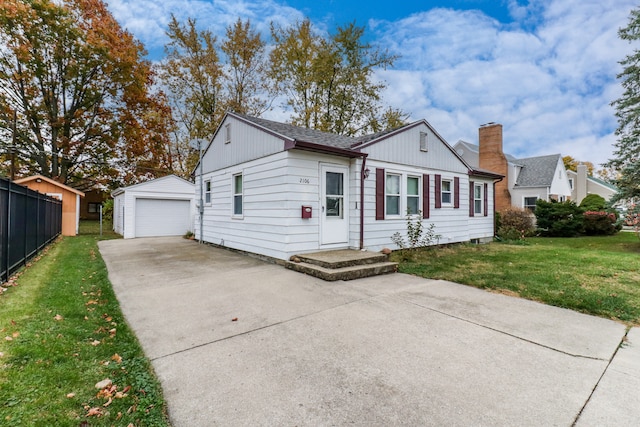 view of front of property featuring an outbuilding, a garage, and a front lawn