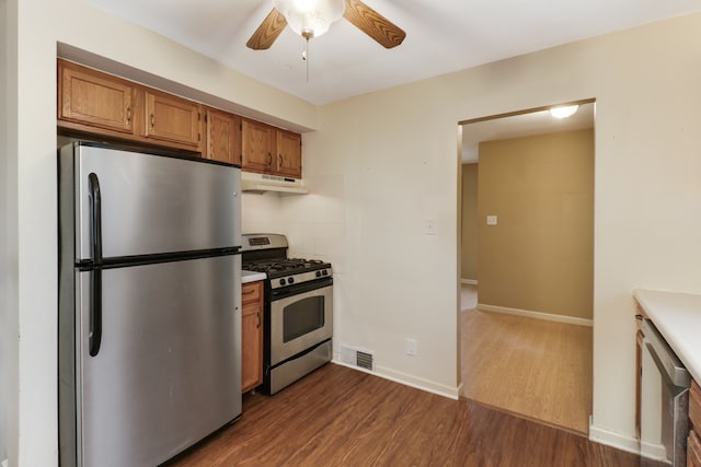 kitchen featuring ceiling fan, decorative backsplash, dark hardwood / wood-style floors, and stainless steel appliances