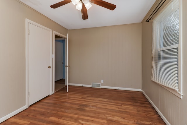 unfurnished bedroom featuring hardwood / wood-style flooring, ceiling fan, and crown molding