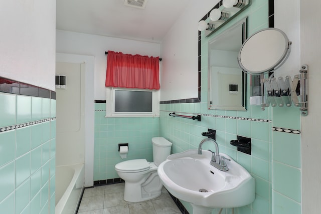 full bathroom featuring tile patterned floors, toilet, tile walls, sink, and independent shower and bath