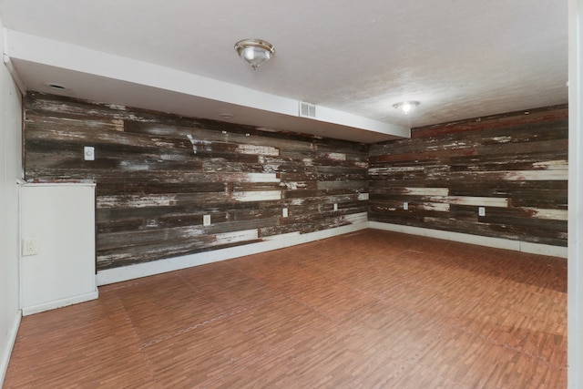 basement with wood walls and hardwood / wood-style flooring