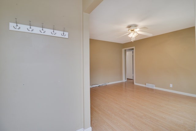 empty room with ceiling fan and light wood-type flooring