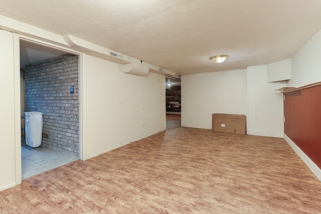 basement with a textured ceiling and brick wall