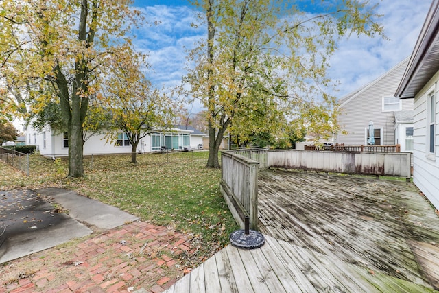 wooden terrace featuring a lawn