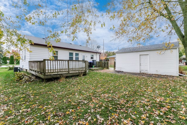 rear view of house featuring central AC unit, a yard, and a deck