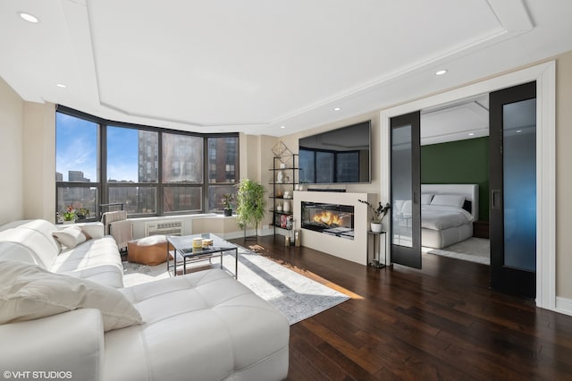 living room featuring dark hardwood / wood-style floors, an AC wall unit, and a wall of windows