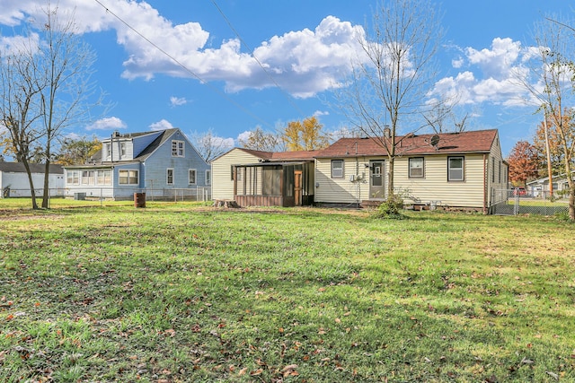 back of property with central AC and a lawn